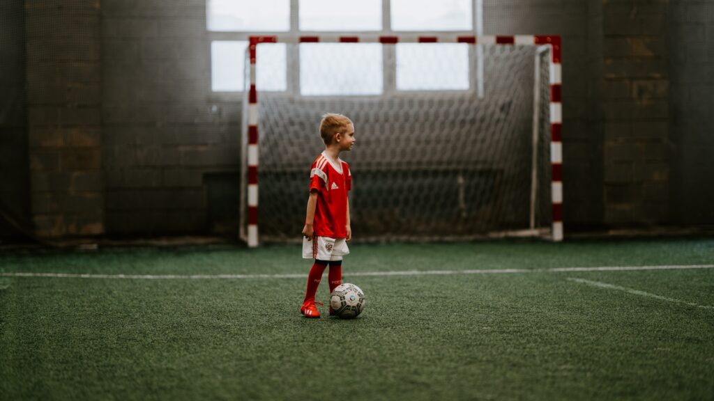 boy standing next to the ball