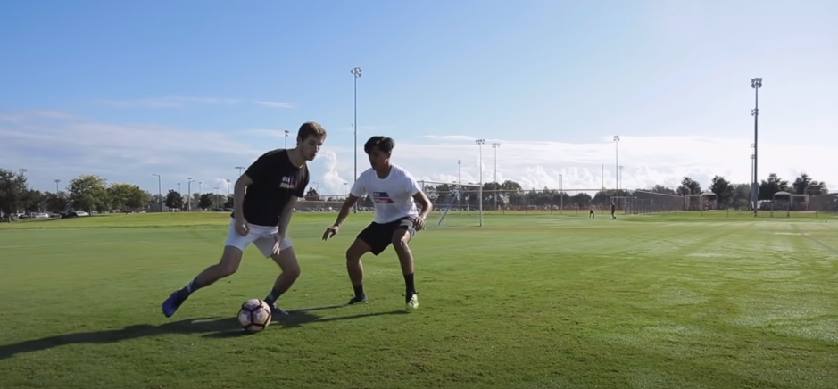 Two individuals having a soccer match on the soccer field